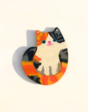 Colorful cat-shaped magnet on a white background