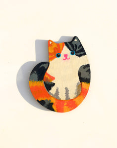 Colorful cat-shaped magnet on a white background