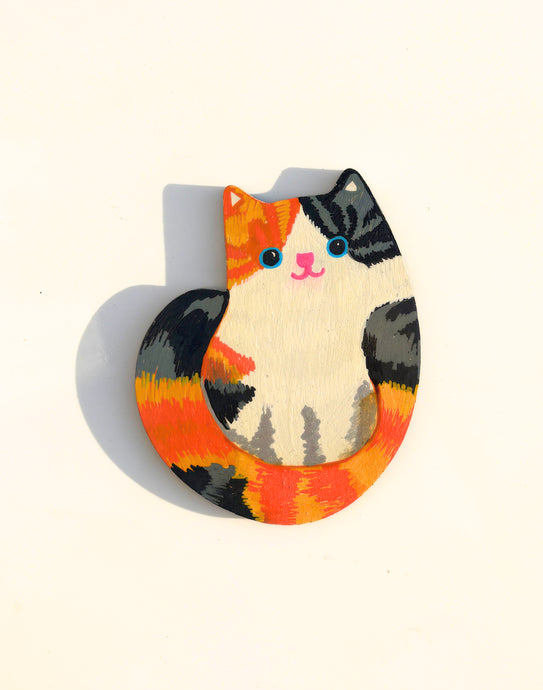Colorful cat-shaped magnet on a white background